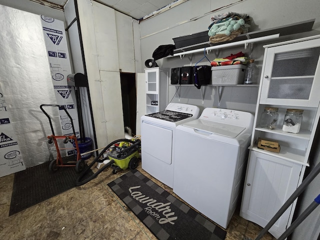 clothes washing area featuring separate washer and dryer and laundry area