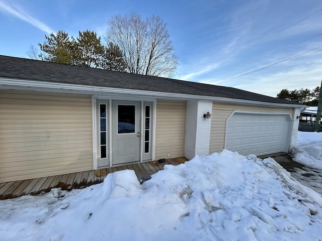 exterior space with an attached garage, brick siding, and a shingled roof