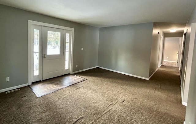 carpeted entrance foyer featuring visible vents and baseboards