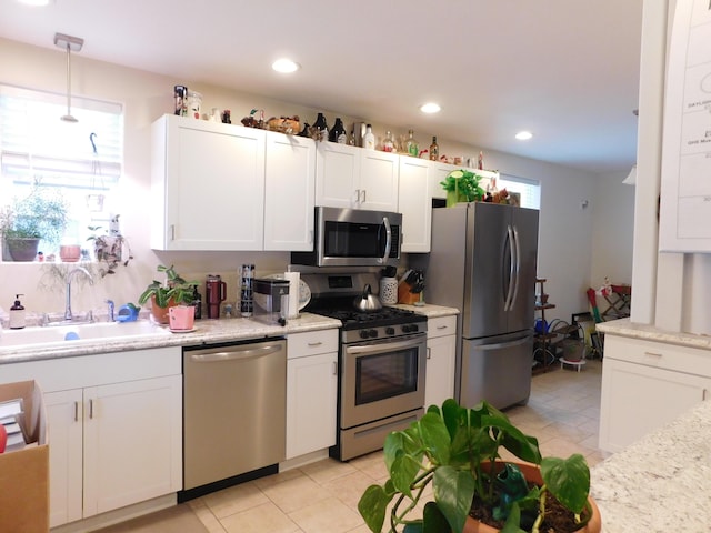 kitchen featuring white cabinetry, stainless steel appliances, a sink, and recessed lighting