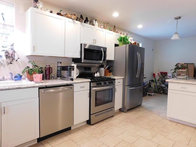 kitchen with stainless steel appliances, recessed lighting, white cabinetry, and decorative light fixtures