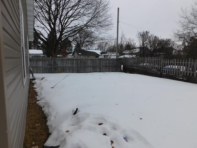 snowy yard featuring fence