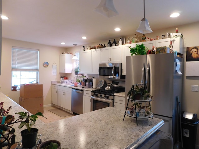 kitchen with hanging light fixtures, appliances with stainless steel finishes, recessed lighting, and white cabinets