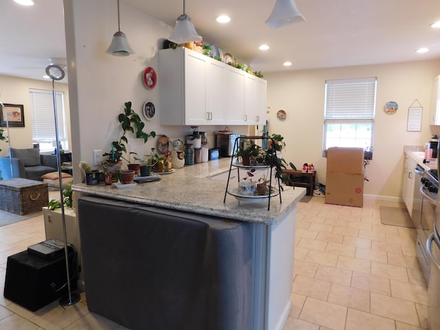 kitchen with recessed lighting, a peninsula, white cabinetry, light stone countertops, and pendant lighting