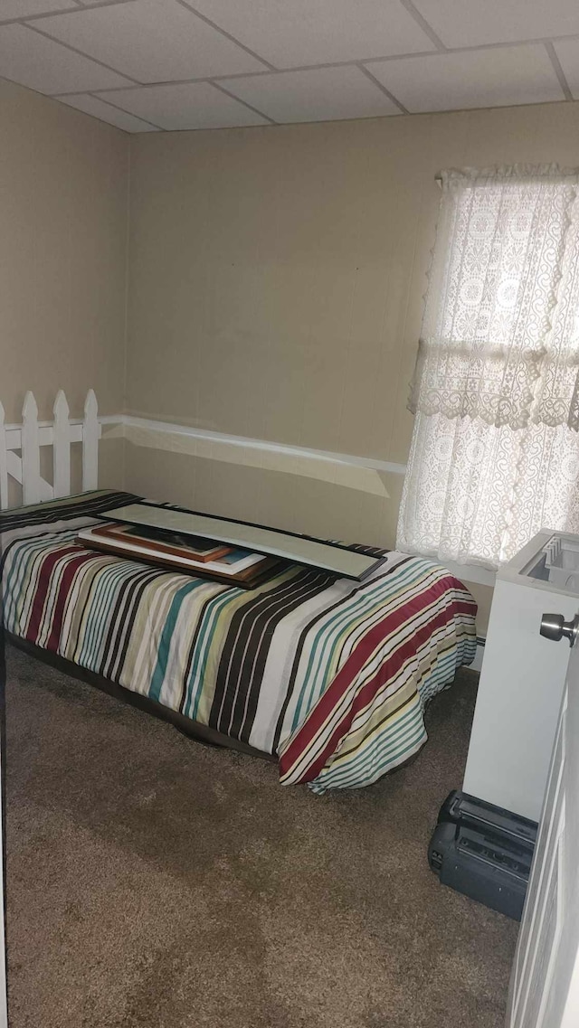 bedroom featuring carpet flooring and a drop ceiling