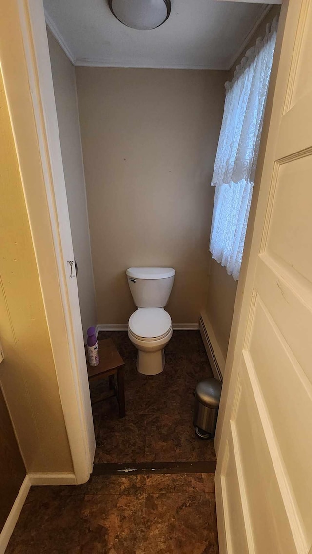 bathroom featuring toilet, baseboards, and a baseboard heating unit