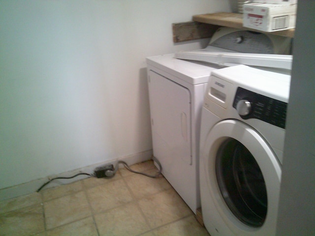 washroom with laundry area, light tile patterned flooring, and washing machine and clothes dryer