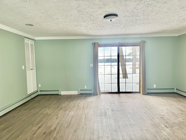 empty room featuring a textured ceiling, ornamental molding, baseboard heating, and wood finished floors