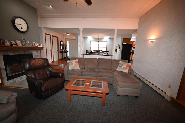 living area with decorative columns, ceiling fan, baseboard heating, carpet flooring, and a fireplace