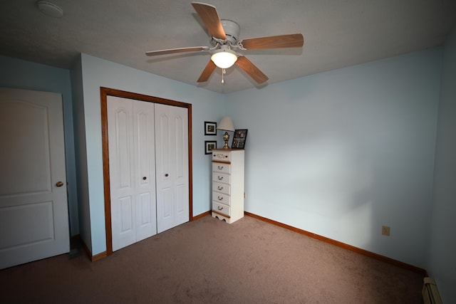 unfurnished bedroom featuring carpet, a closet, baseboard heating, a ceiling fan, and baseboards