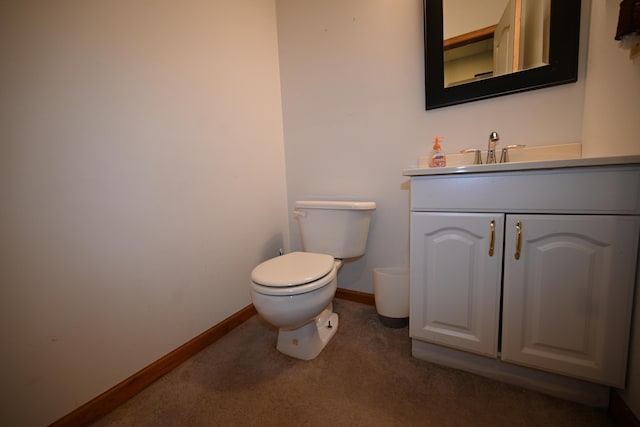 half bathroom featuring toilet, vanity, and baseboards