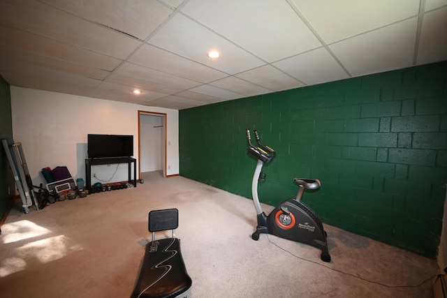 exercise area with a drop ceiling, carpet flooring, concrete block wall, and recessed lighting