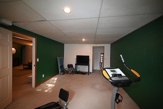 exercise area with concrete block wall and a drop ceiling