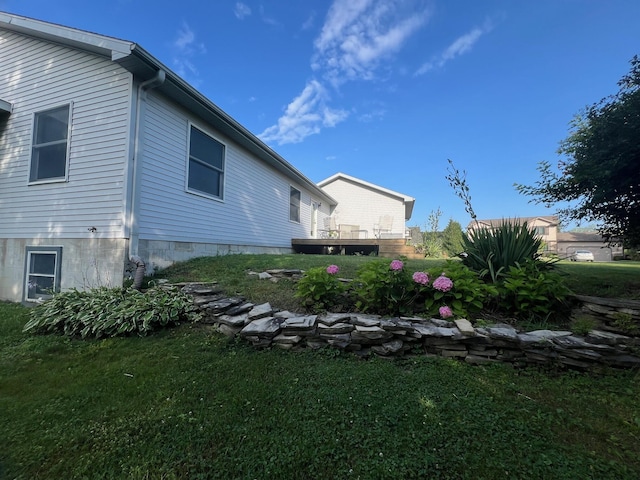 view of side of property with a yard and a wooden deck