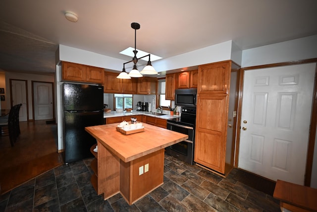 kitchen featuring butcher block countertops, a center island, freestanding refrigerator, stone finish flooring, and double oven range