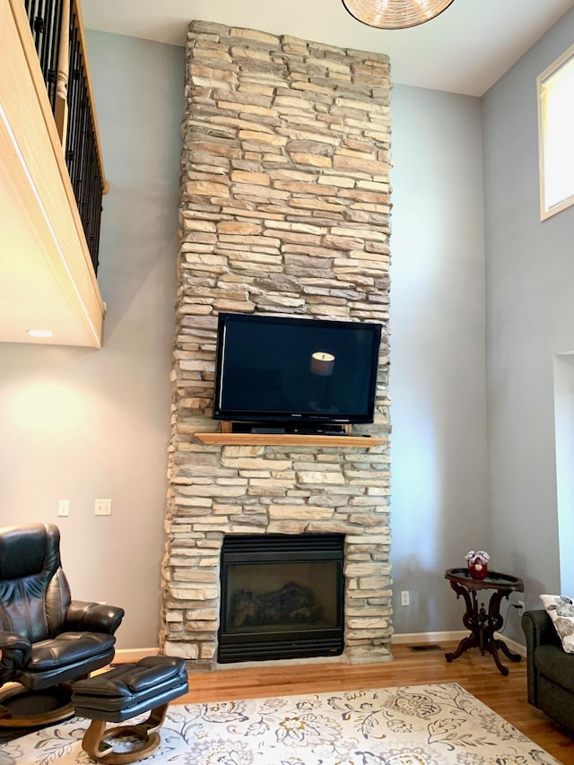 living area featuring a fireplace, baseboards, and wood finished floors