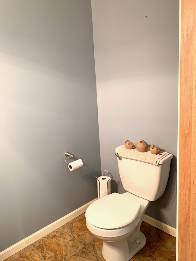 bathroom with toilet and baseboards