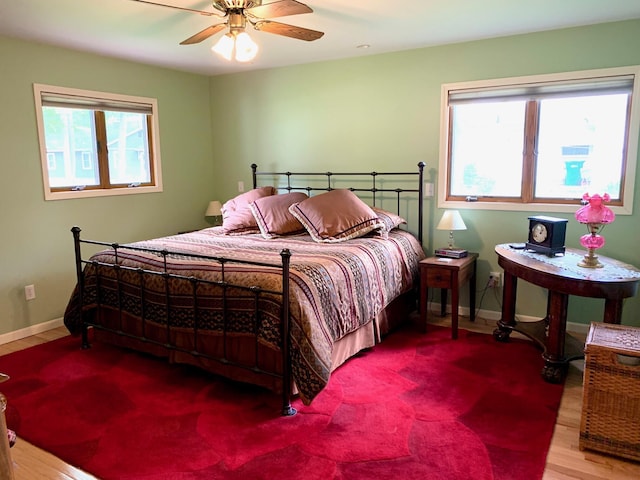 bedroom featuring ceiling fan, wood finished floors, and baseboards