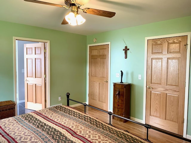 bedroom with ceiling fan, baseboards, and wood finished floors