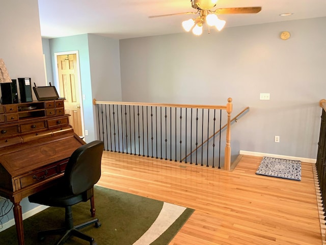 office area featuring ceiling fan, wood finished floors, and baseboards