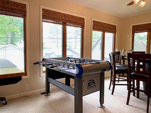 rec room featuring carpet floors, baseboards, and a ceiling fan