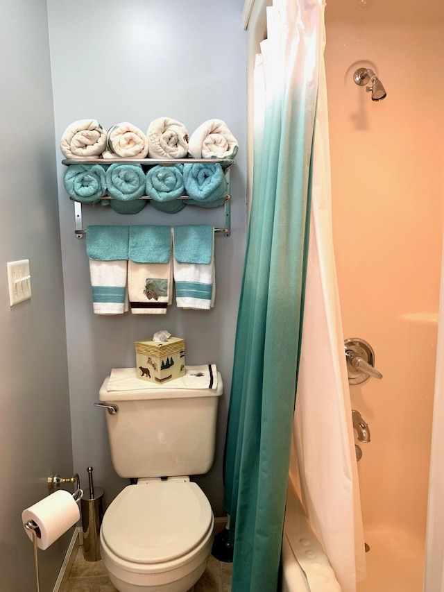 full bathroom with toilet, a shower with curtain, and baseboards