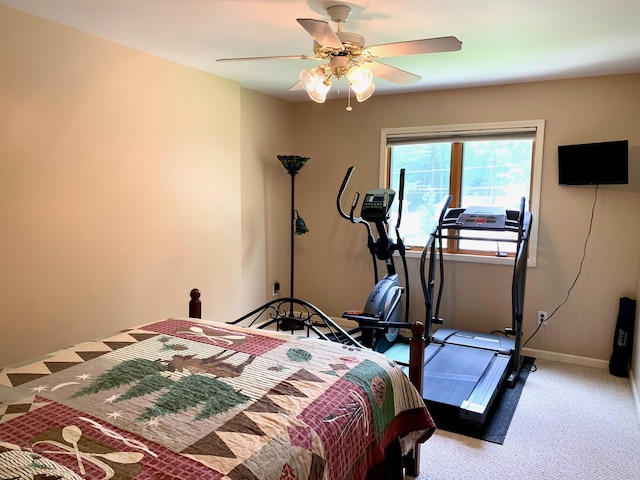 carpeted bedroom with ceiling fan and baseboards