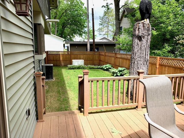 wooden terrace with a yard, fence, and central air condition unit