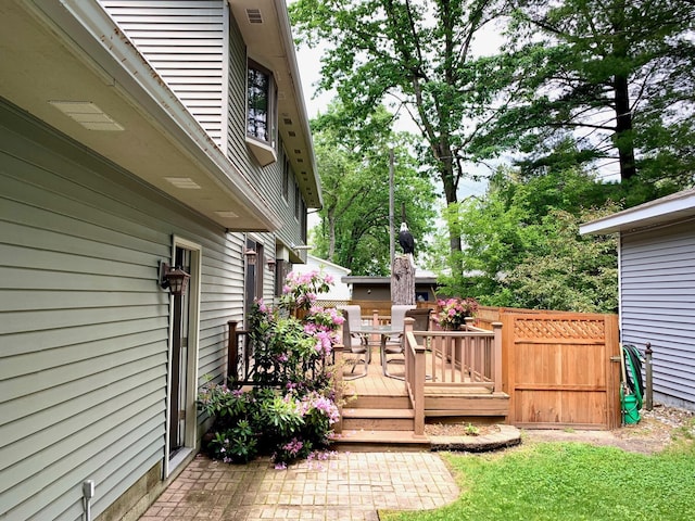 wooden deck with outdoor dining area and visible vents