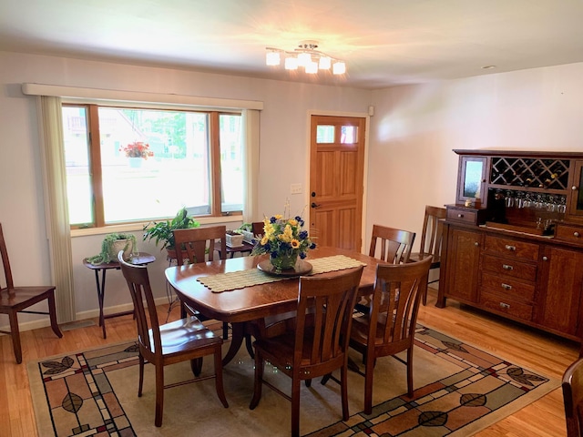 dining area with light wood-type flooring and baseboards