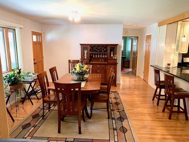 dining space featuring light wood-style floors and baseboards