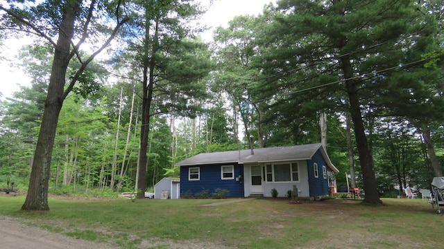 ranch-style house with a front yard and an outbuilding