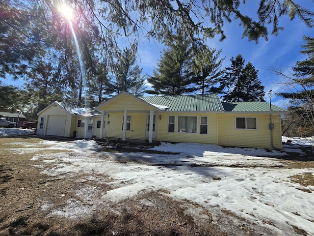 view of front facade with metal roof and an attached garage