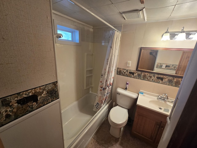 bathroom with shower / tub combo with curtain, tile walls, toilet, vanity, and tile patterned flooring