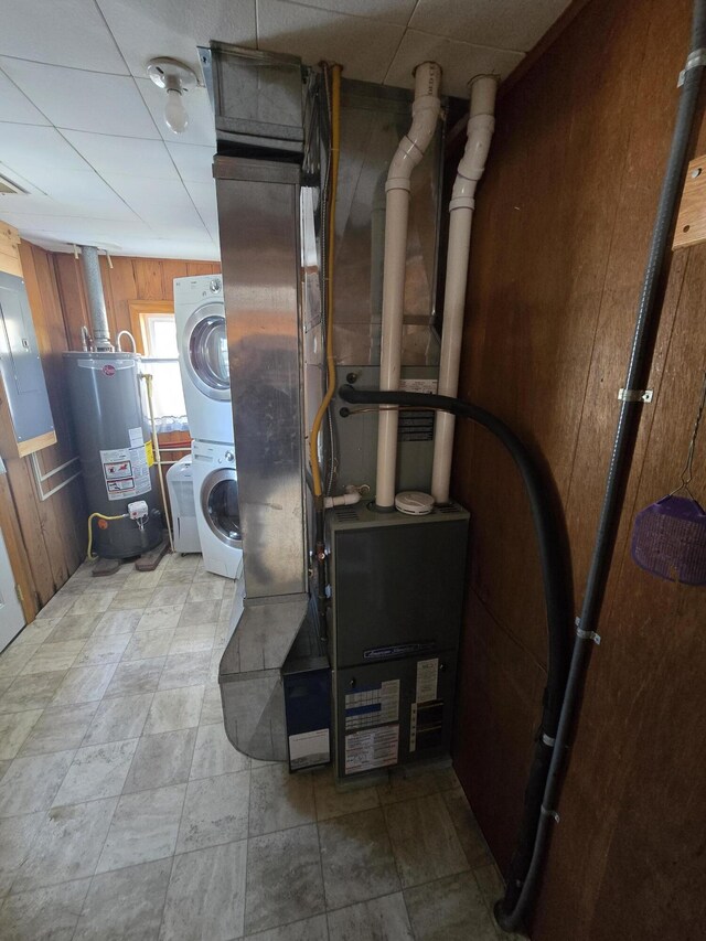 utilities featuring stacked washer / drying machine and gas water heater