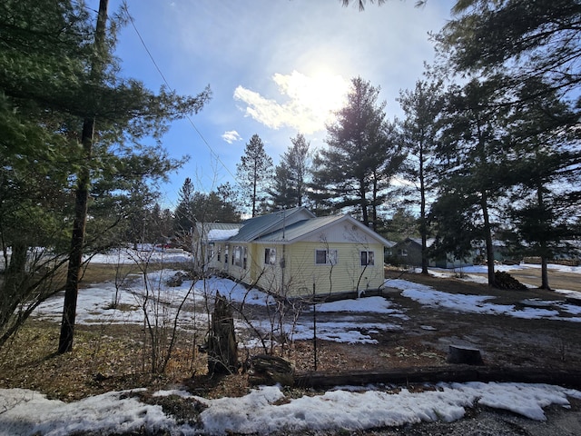 snow covered property featuring metal roof