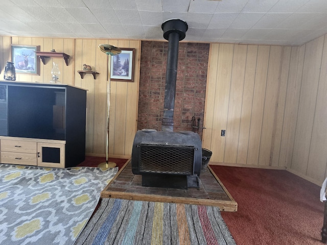 details featuring carpet flooring, a wood stove, and wooden walls