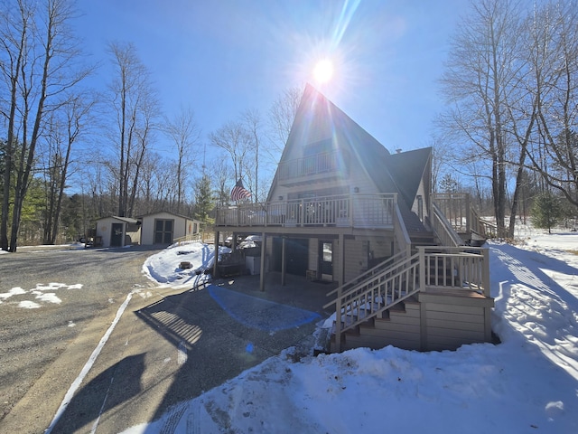 view of front of house featuring stairway, an outdoor structure, and a wooden deck