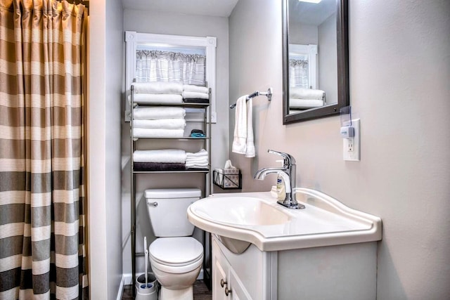 bathroom featuring vanity, curtained shower, and toilet