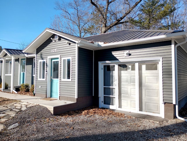 exterior space with a garage, metal roof, and a standing seam roof