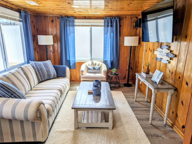 living area with wooden ceiling, wood finished floors, and wood walls