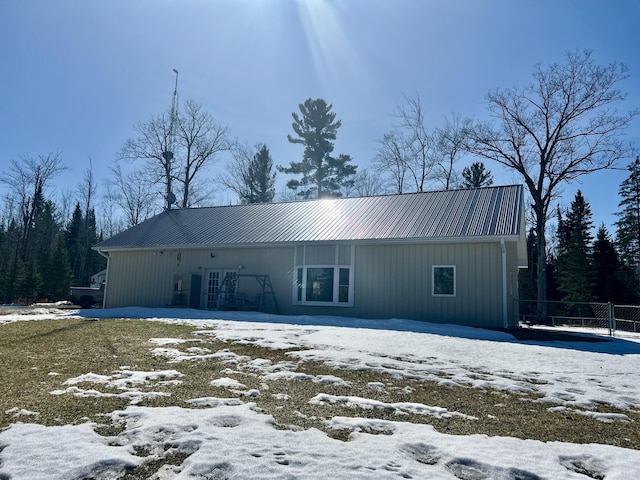 exterior space with metal roof and fence