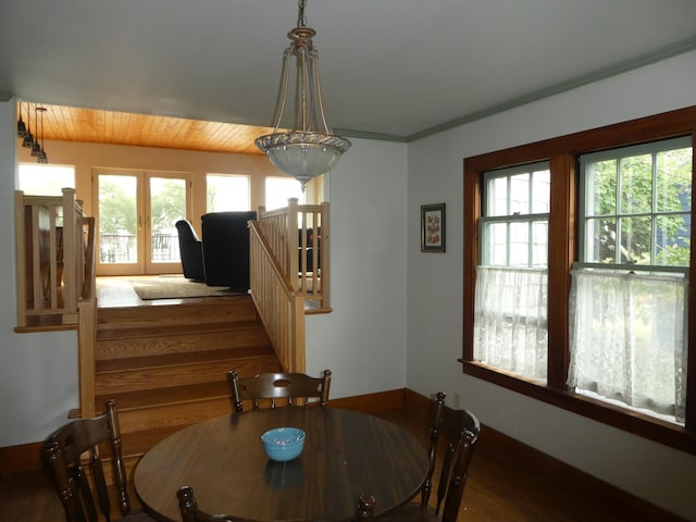 dining room featuring crown molding, dark wood-type flooring, and a wealth of natural light