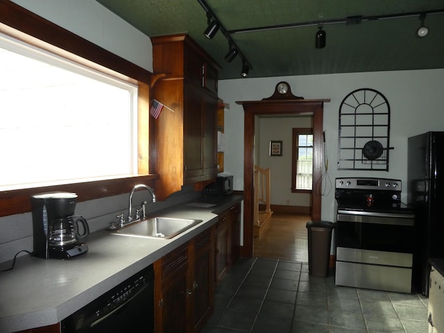 kitchen with sink, rail lighting, dark tile floors, and black appliances