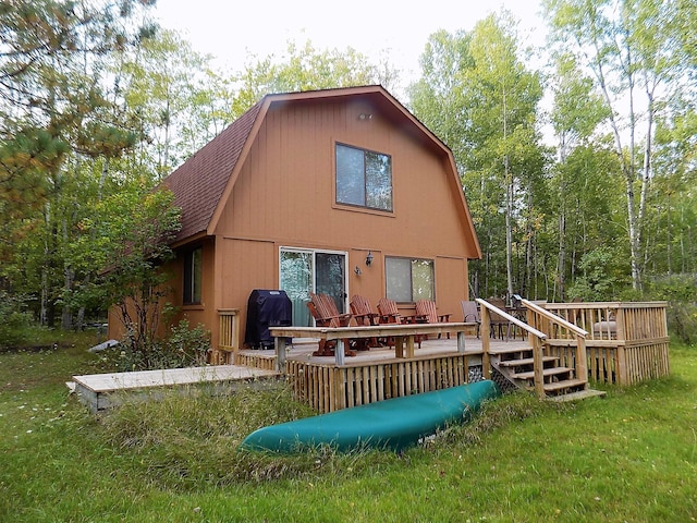 rear view of house featuring a lawn and a deck