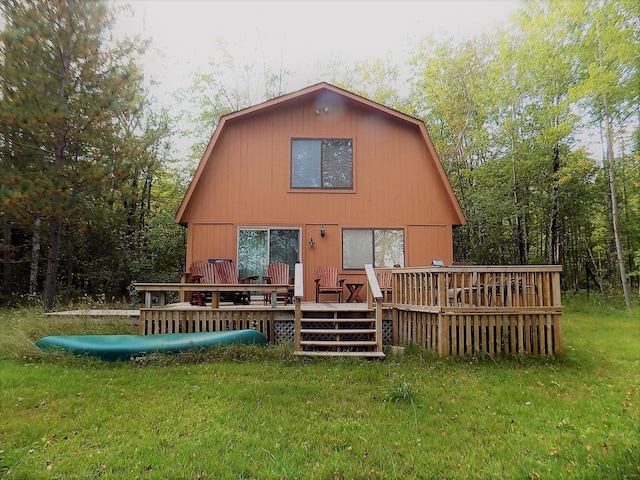 back of house with a wooden deck and a lawn