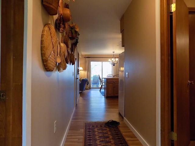 hallway with a notable chandelier and light hardwood / wood-style flooring