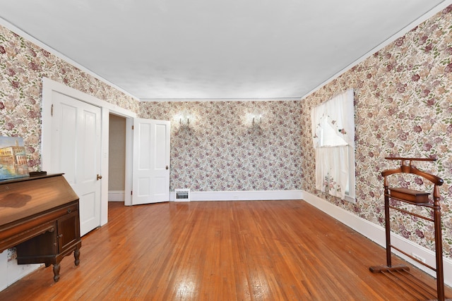 unfurnished room featuring light wood-type flooring and ornamental molding