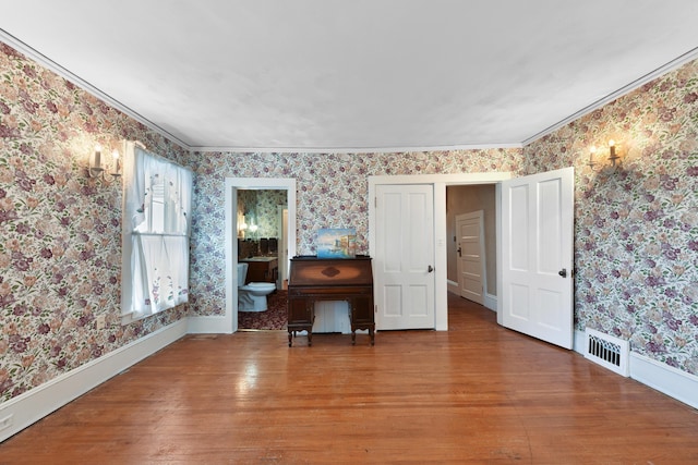 unfurnished living room featuring ornamental molding and dark hardwood / wood-style flooring