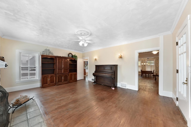 living room with dark wood-type flooring, crown molding, and ceiling fan